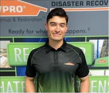 man standing in front of green disaster recovery team sign